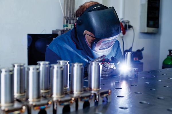 Schweißer während der Arbeit mit Laserschweißgerät